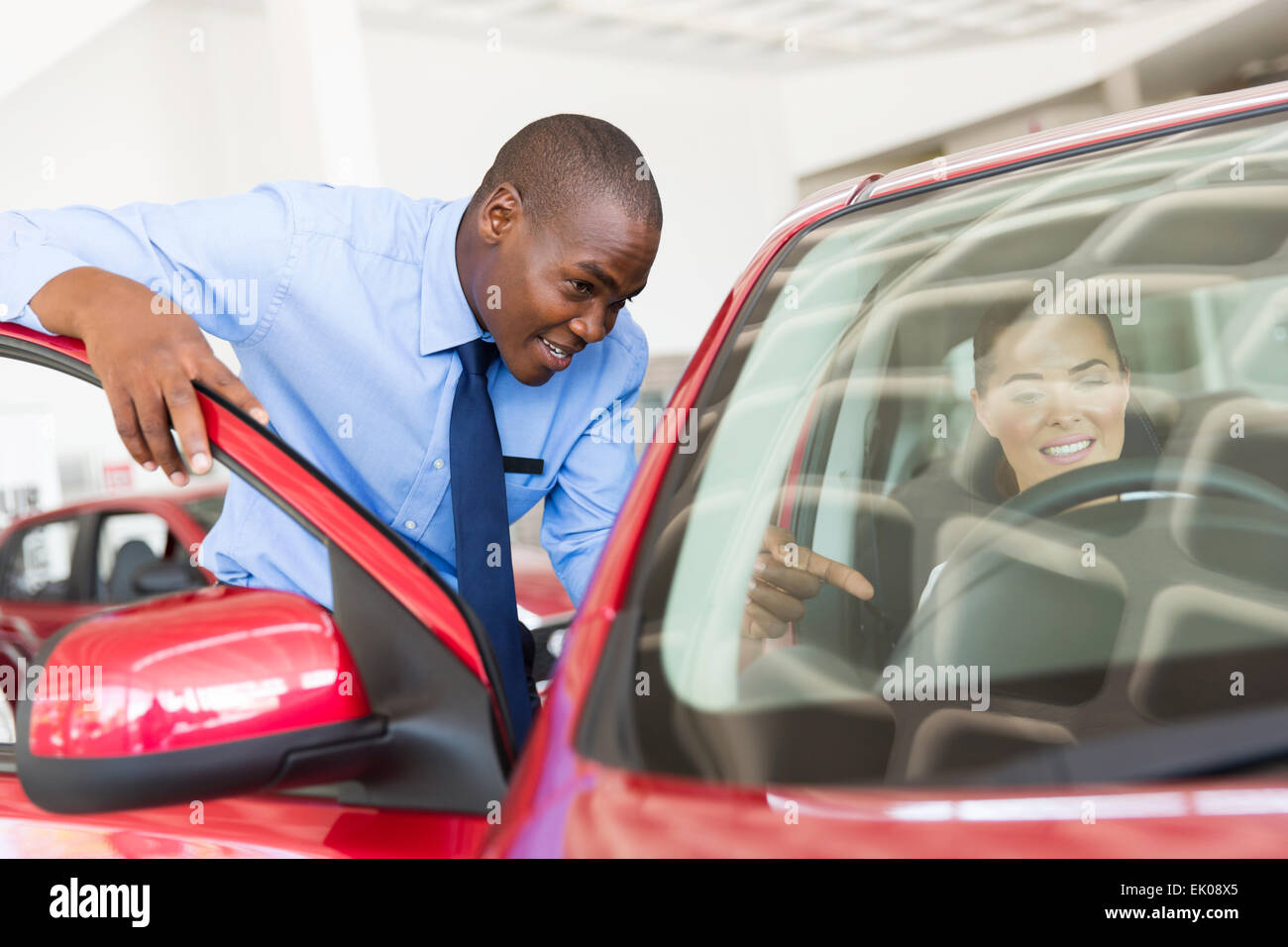 handsome African salesman explaining car features to potential customer Stock Photo