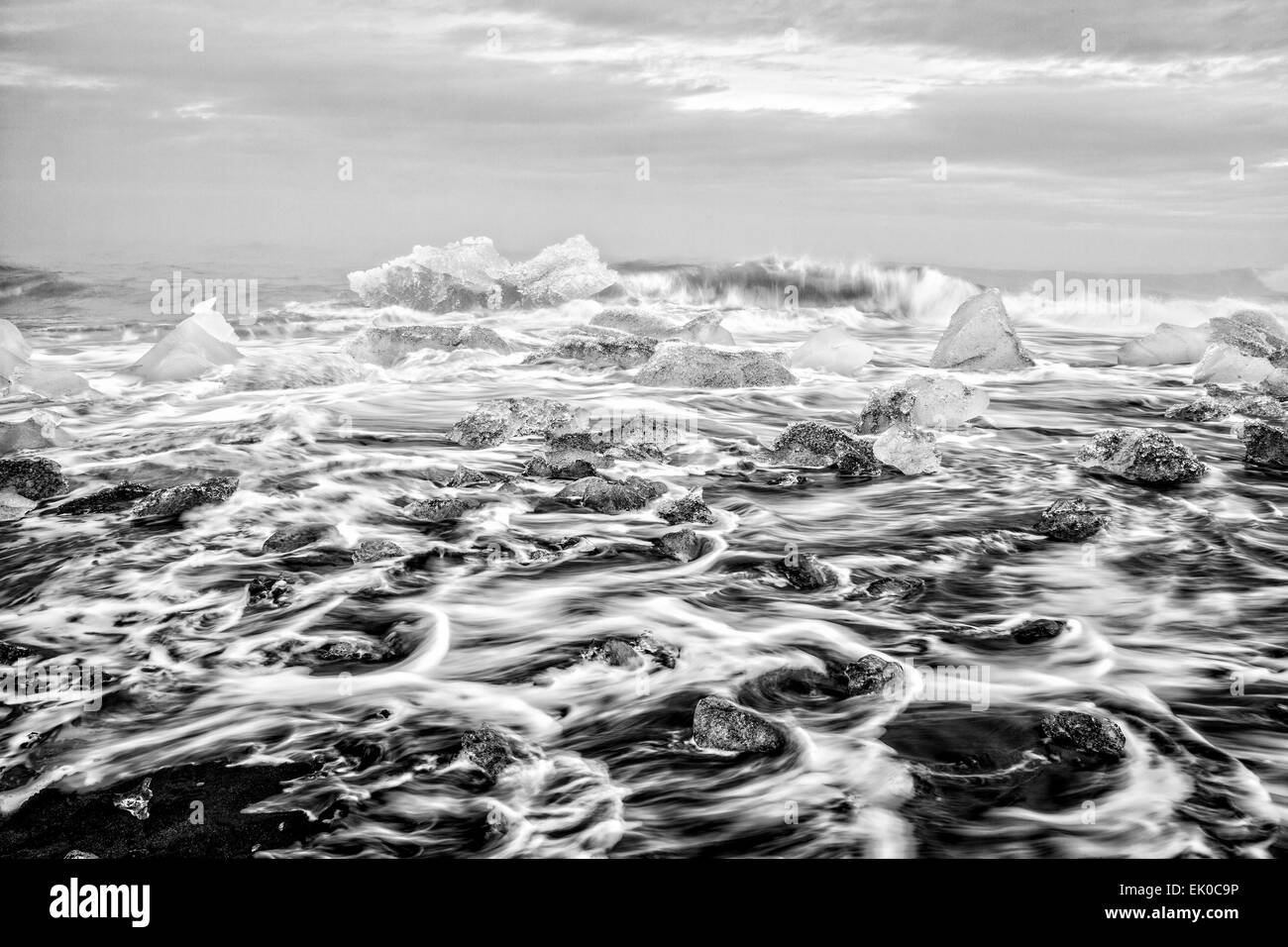 View of chunks of icebergs and ocean surf on the black sand beach in Jokulsarlon, Iceland Stock Photo
