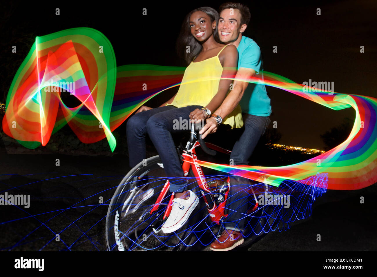 Interracial couple riding a bicycle Stock Photo
