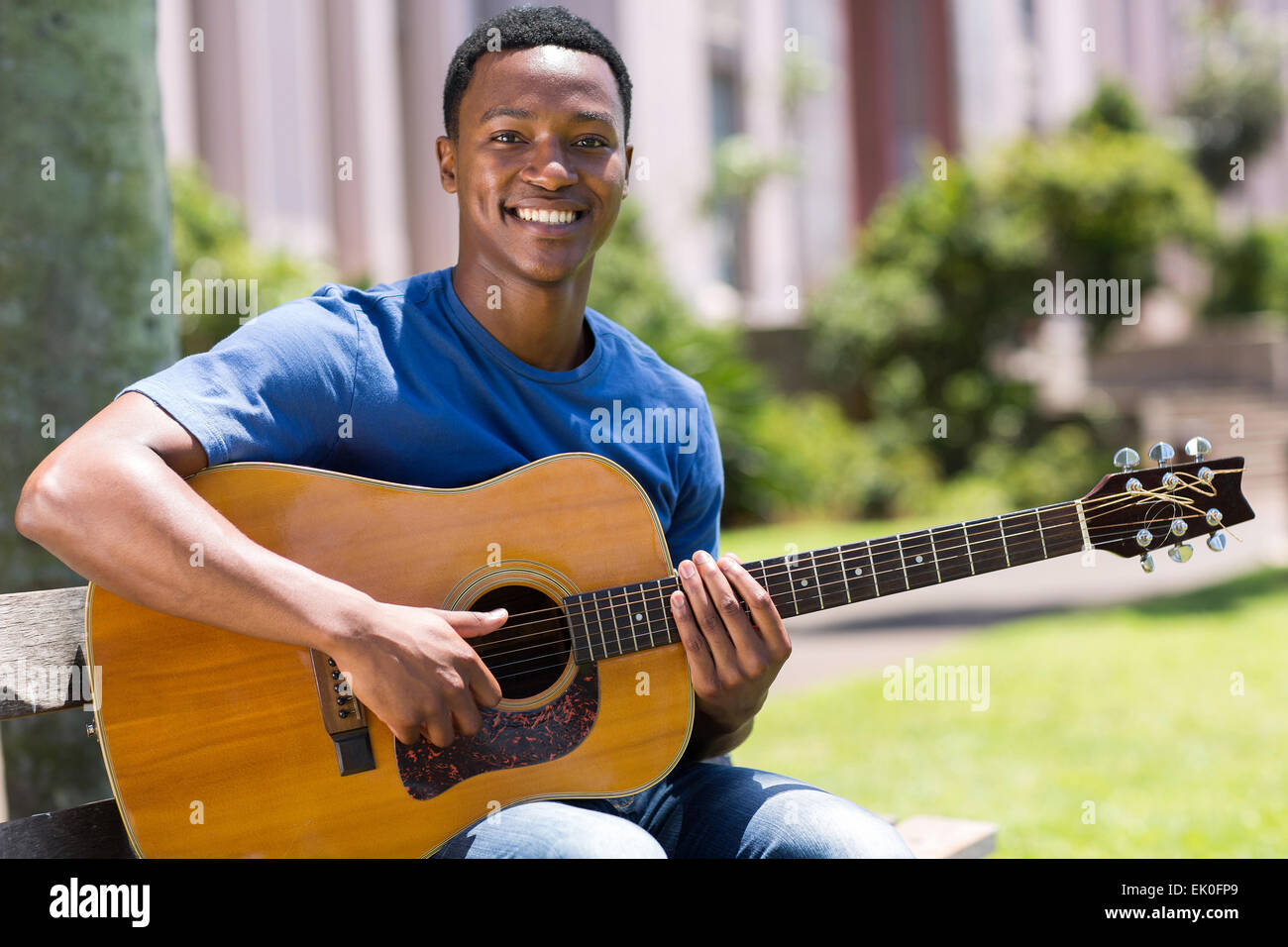 cheerful young African American man playing guitar outdoors Stock Photo ...