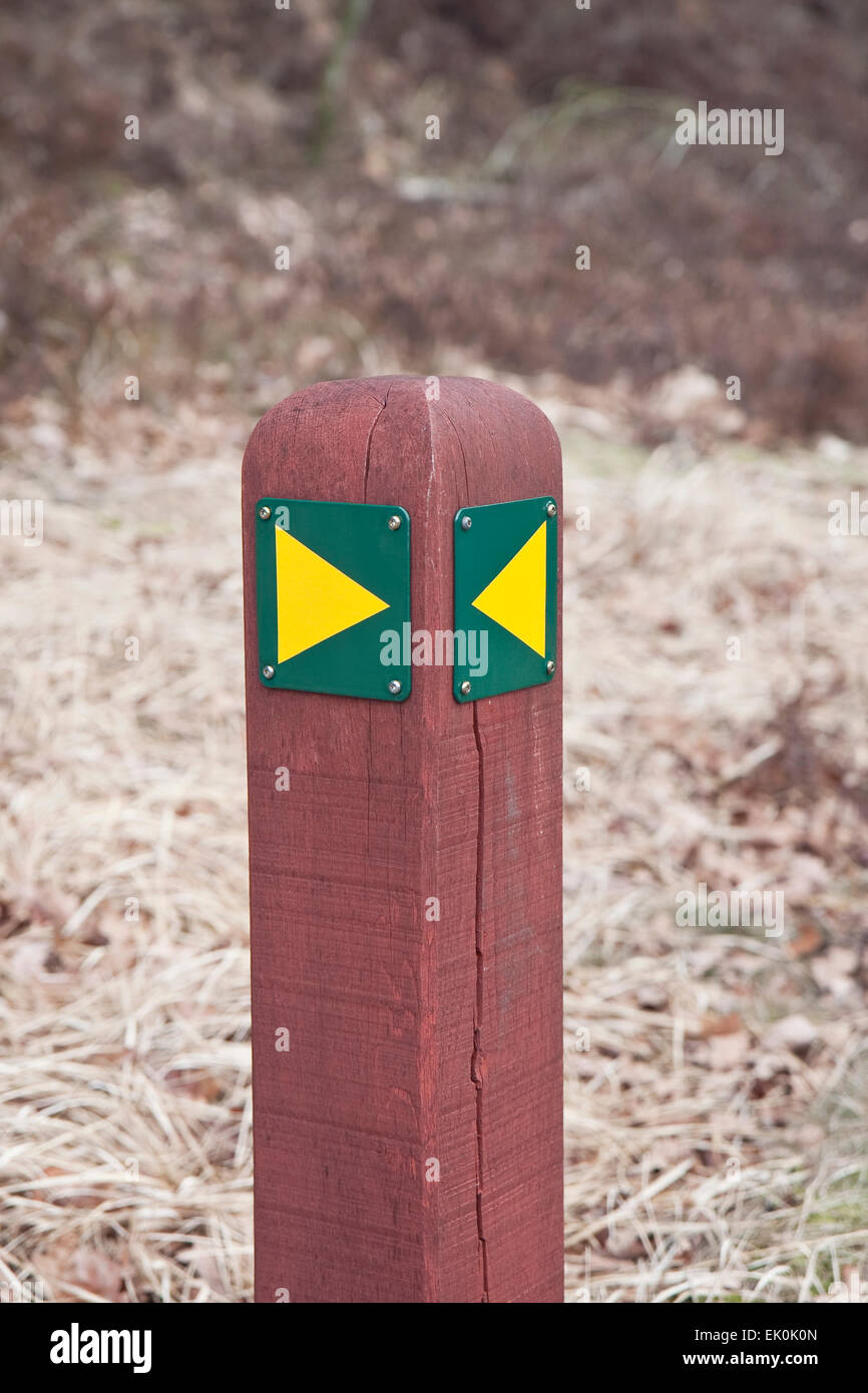 Hiking sign. Yellow arrows on a red pole. Stock Photo