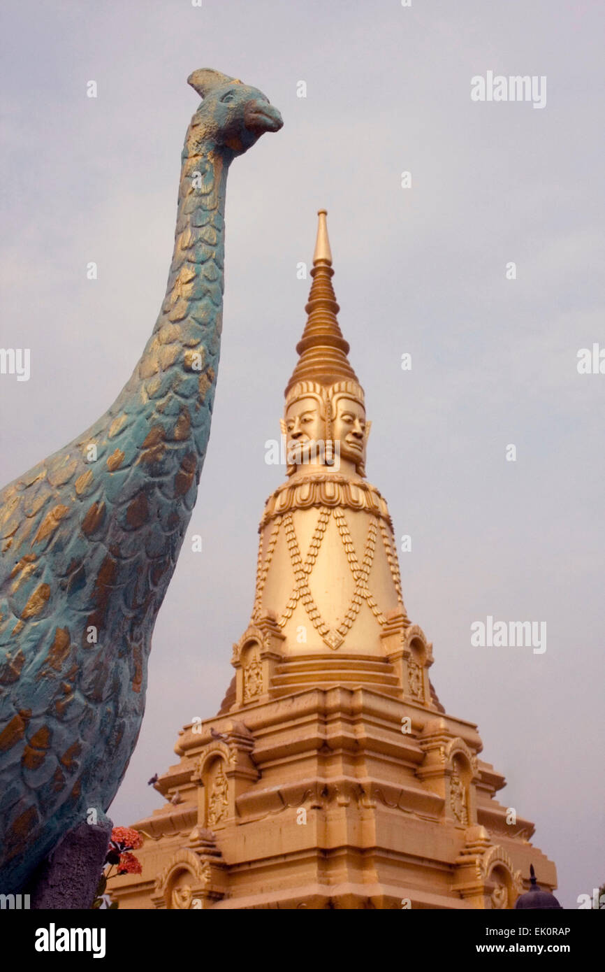 A golden stupa and a peacock sculpture are on display at a temple in Kampong Cham, Cambodia. Stock Photo