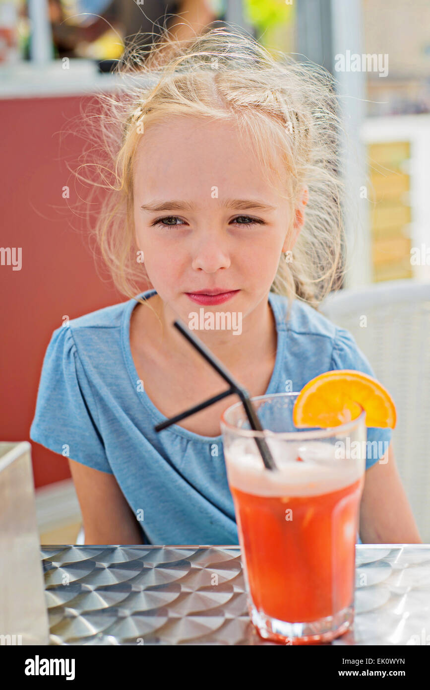 Little girl drinking orange juice Stock Photo Alamy