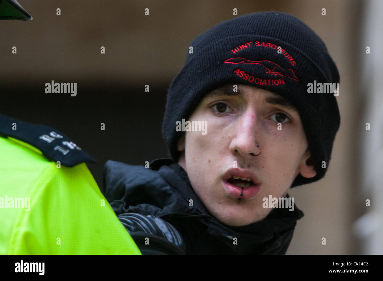 Whitehall, London, April 4th 2015. As PEGIDA UK holds a poorly attended rally on Whitehall, scores of police are called in to contain counter protesters from various London anti-fascist movements. PICTURED: Wearing a hunt saboteurs hat, a young anti-fascist counter-protester stares into the camera as he is arrested after attempting to break through police lines into the PEGIDA rally. Credit:  Paul Davey/Alamy Live News Stock Photo