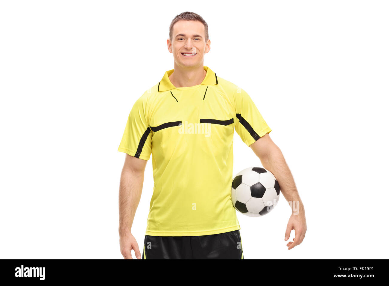 Male football referee in a yellow jersey holding a ball and looking at camera isolated on white background Stock Photo