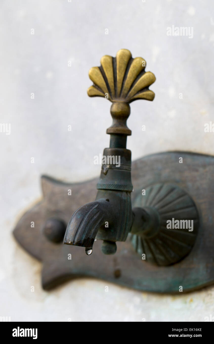 Drop of water dripping closeup from Turkish ottoman style antique water tap. Antique Ottoman faucet Stock Photo