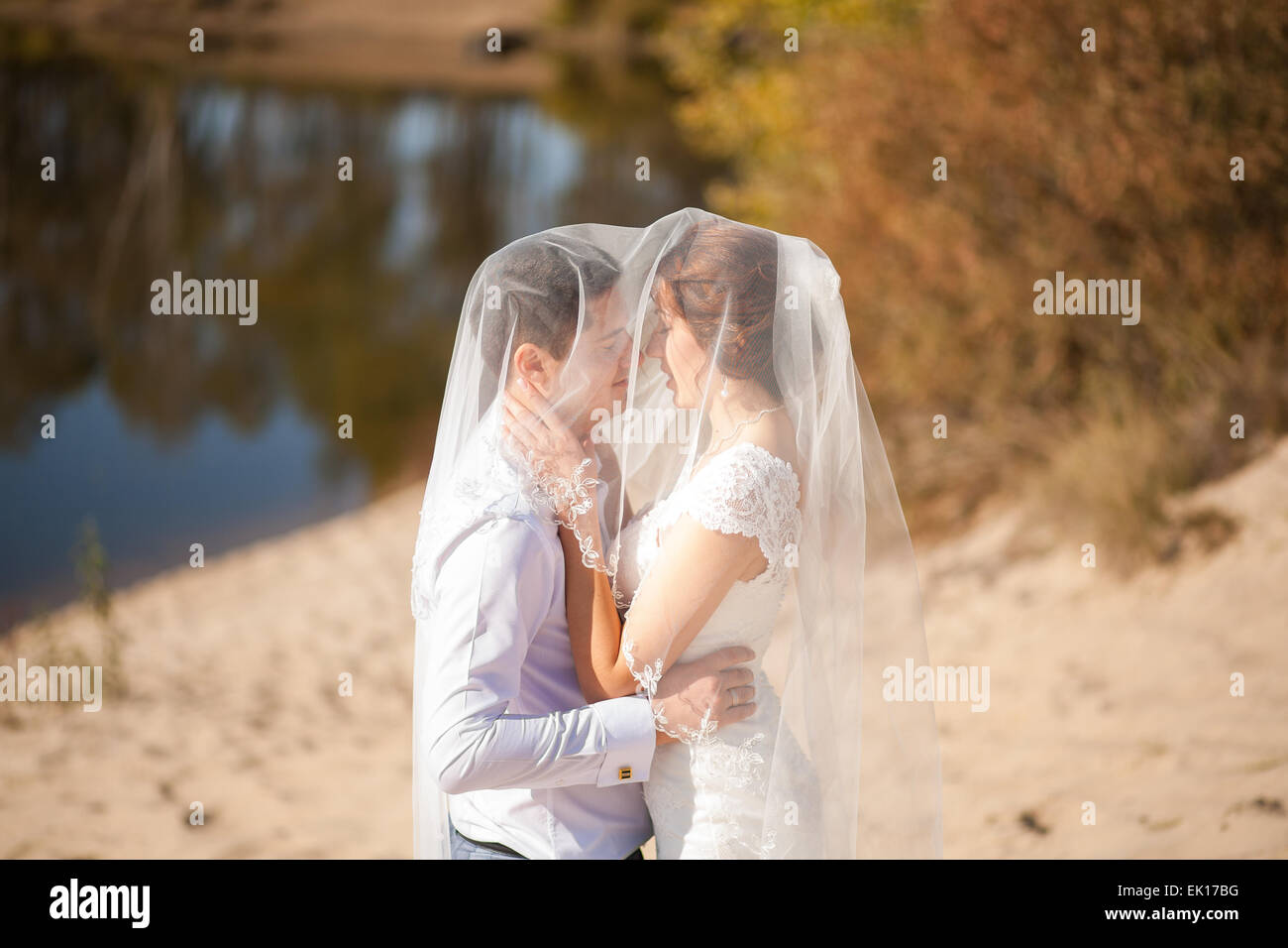 bride and groom, kissing on a beach, romantic married couple Stock Photo