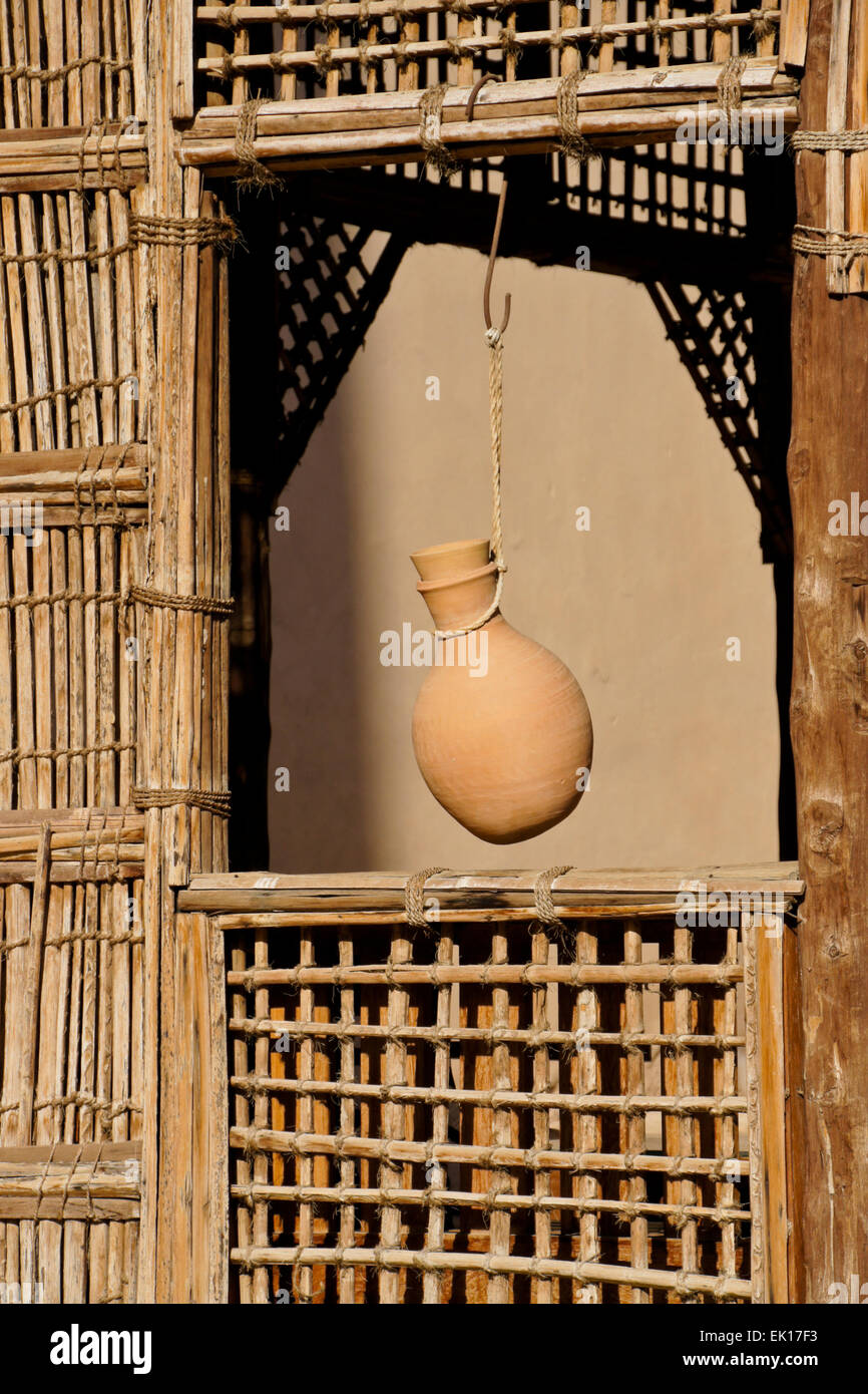 Pottery water jug hanging in window of latticed wood shelter, Nizwa Fort, Nizwa, Oman Stock Photo