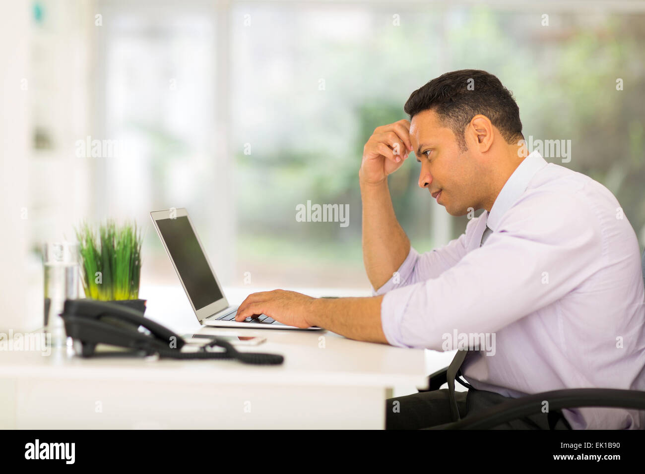worried middle aged businessman looking at computer screen Stock Photo