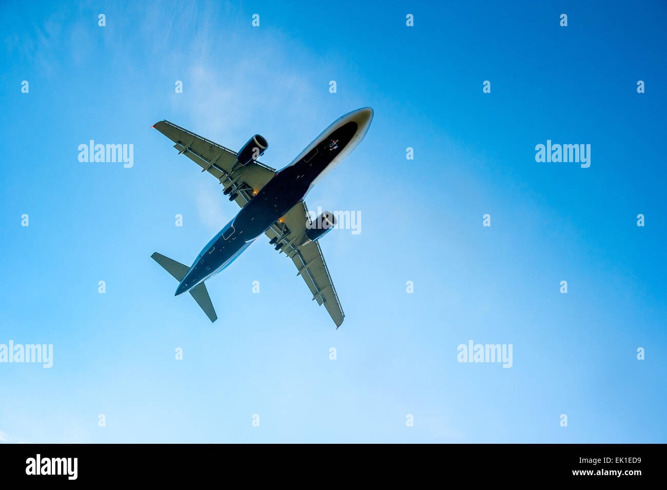 airplane in the blue cloudless sky is landing Stock Photo
