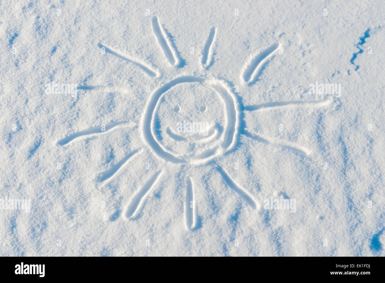 smiling sun drawn on the surface of the snow in the winter Stock Photo ...