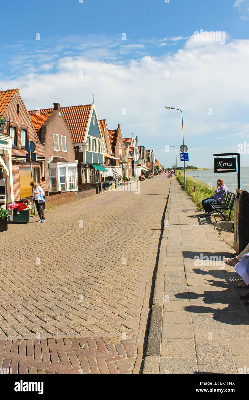 VOLENDAM,THE NETHERLANDS - JULY 7, 2012 : Tourists in the port  Volendam. Volendam is an international tourist attraction that introduces visitors to the life of the Dutch fishermen in the old days. Stock Photo