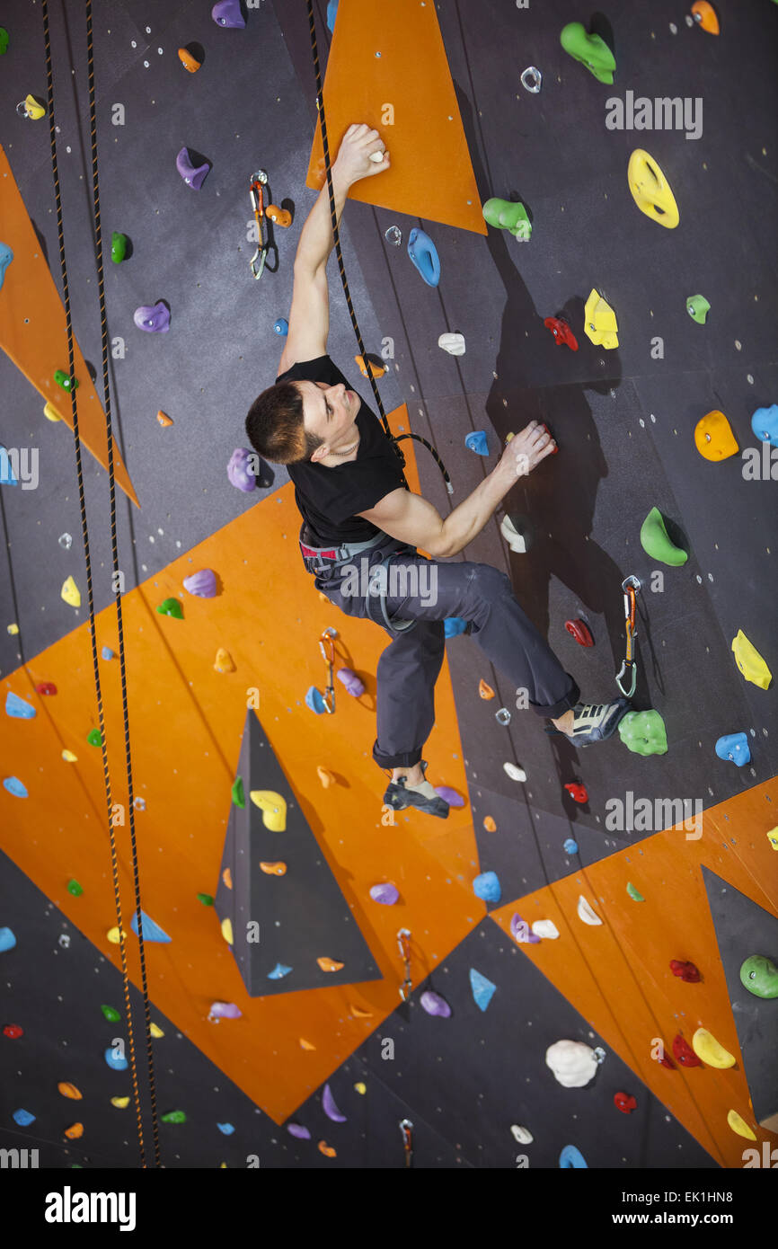 Young man practicing top rope climbing in indoor climbing gym Stock Photo -  Alamy