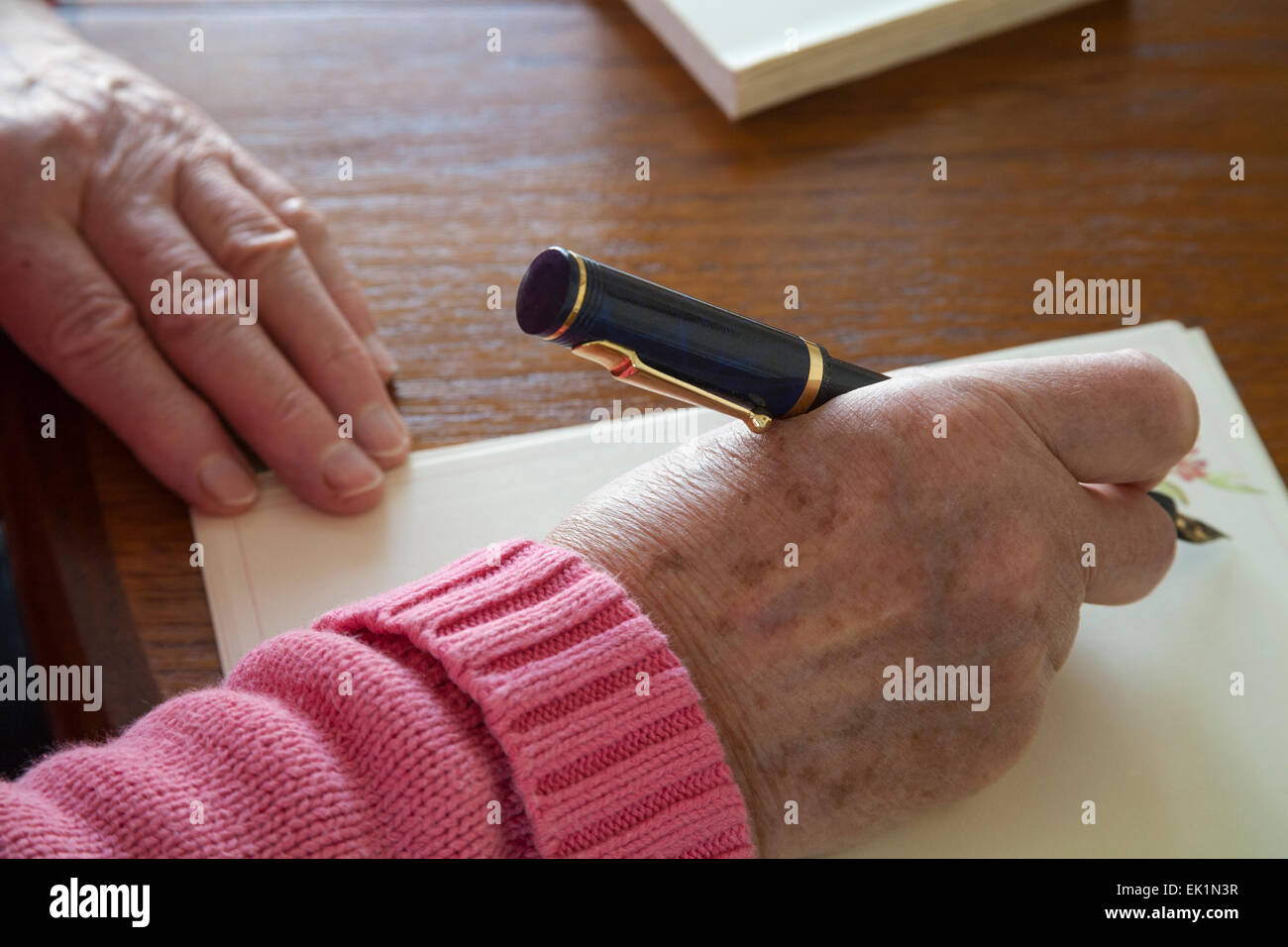 Close up Elderly woman using fountain pen to write letter of thanks ...