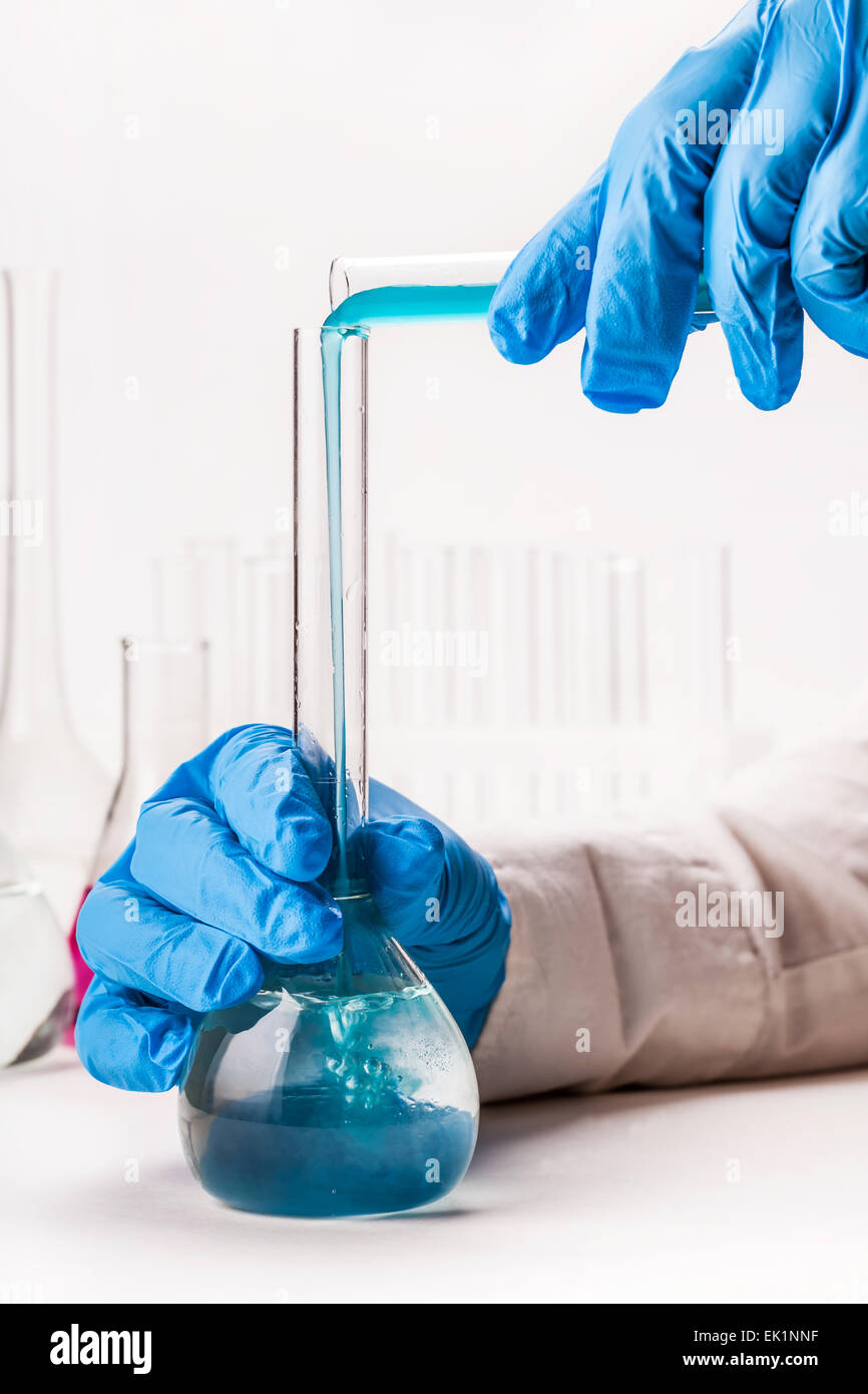 laboratorian pours reagent in the flask on a white background Stock ...