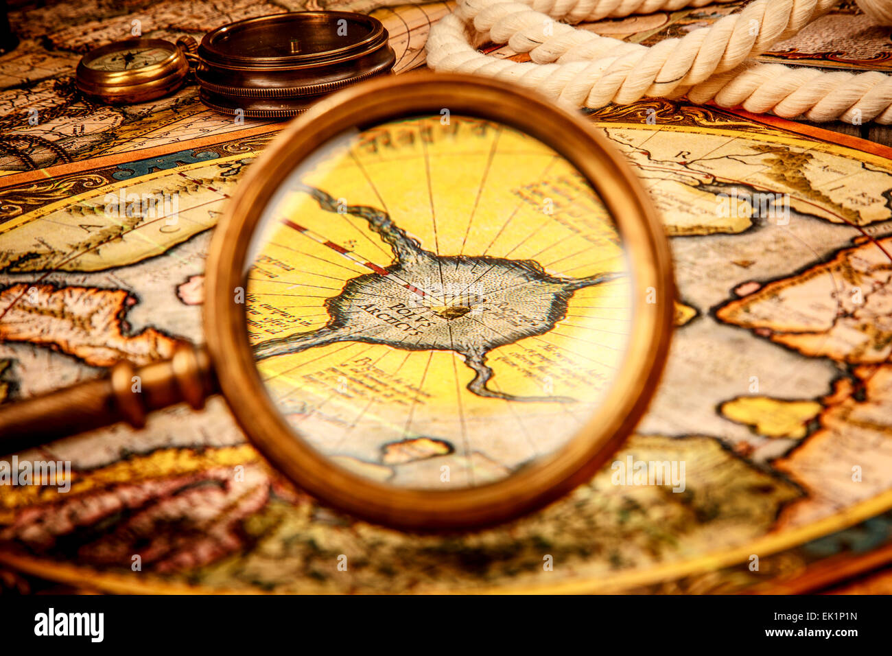 Vintage magnifying glass lies on the ancient map of the North Pole (also Hyperborea). Arctic continent on the Gerardus Mercator Stock Photo