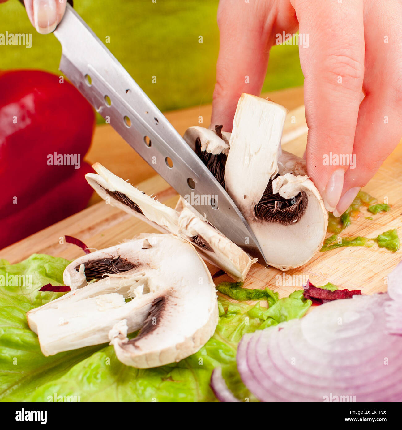 Woman's hands cutting mushroom champignon Stock Photo
