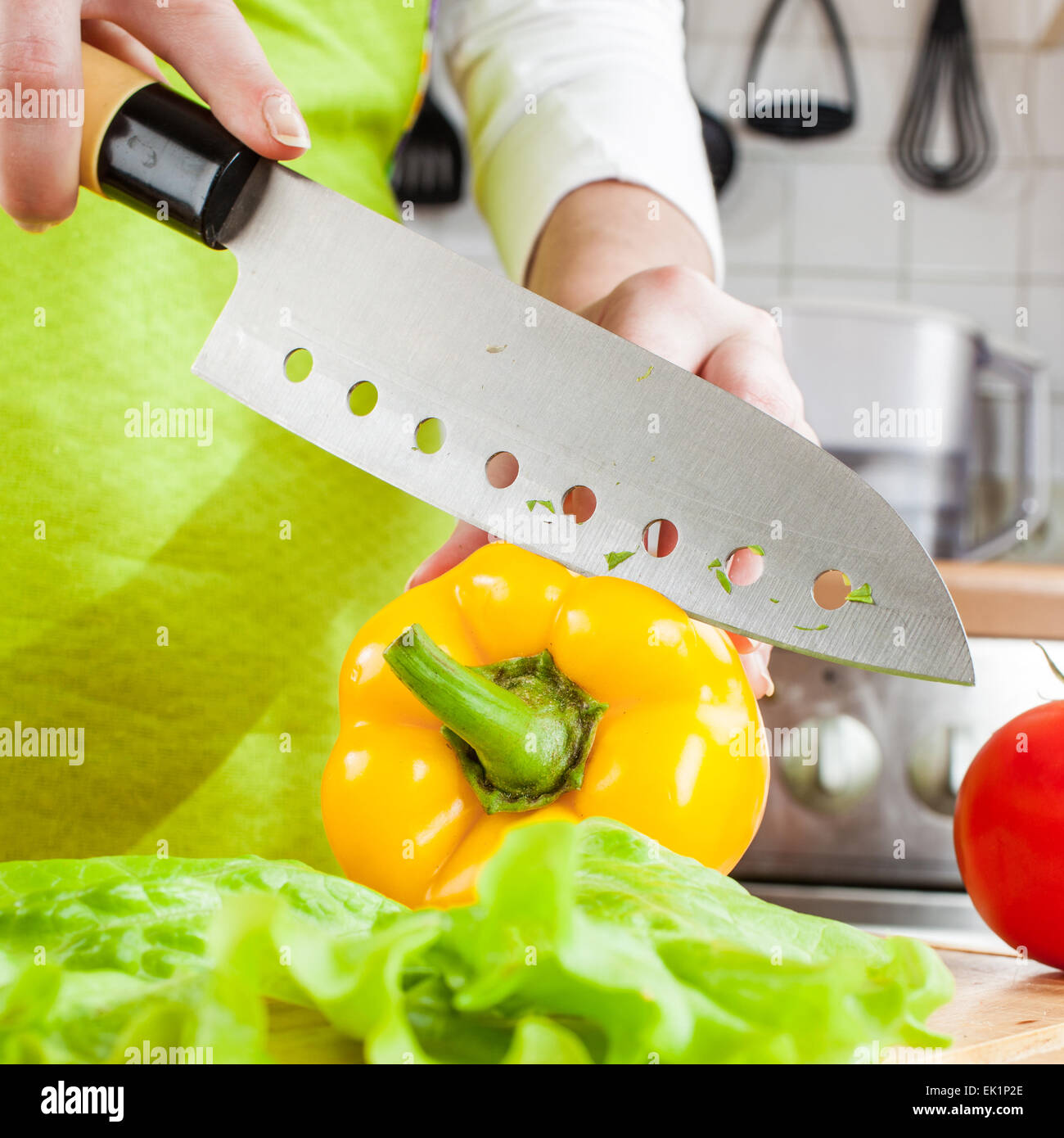 Woman's hands cutting fresh bell pepper on kitchen Stock Photo