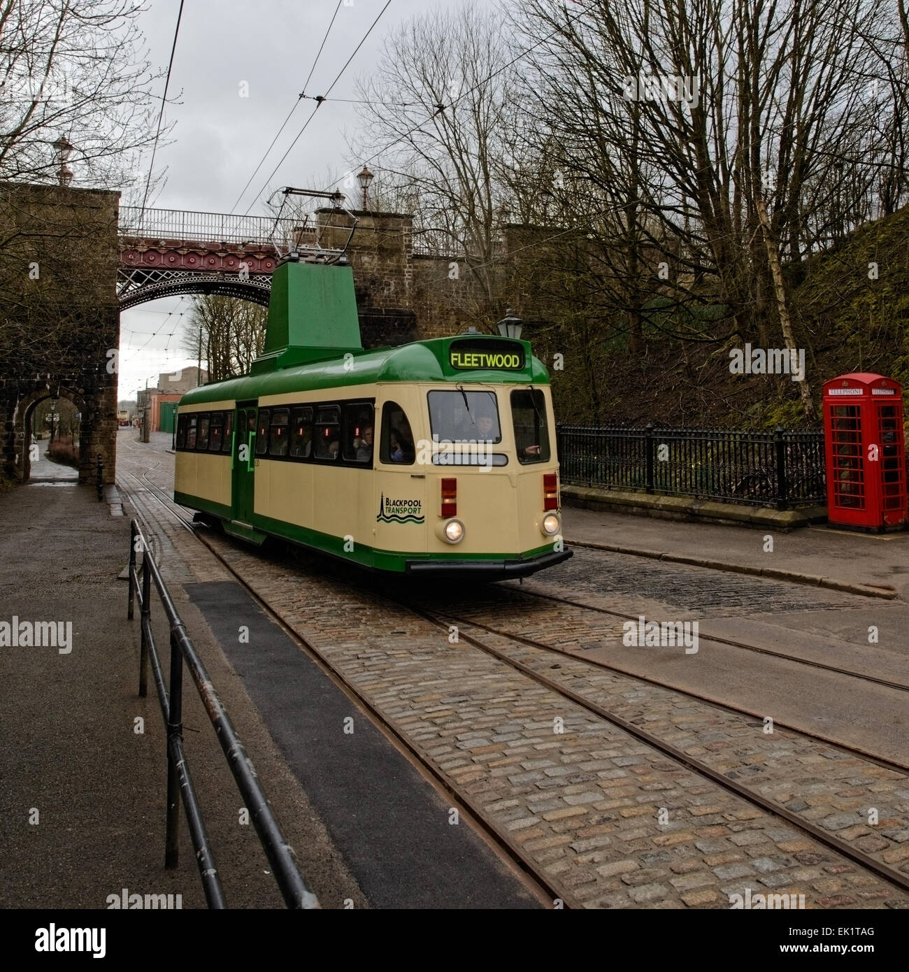 Single Decker Tram 630 (Blackpool 1937) driven under the Bowes-Lyon Bridge along the rails past an iconic (K6) telephone box Stock Photo