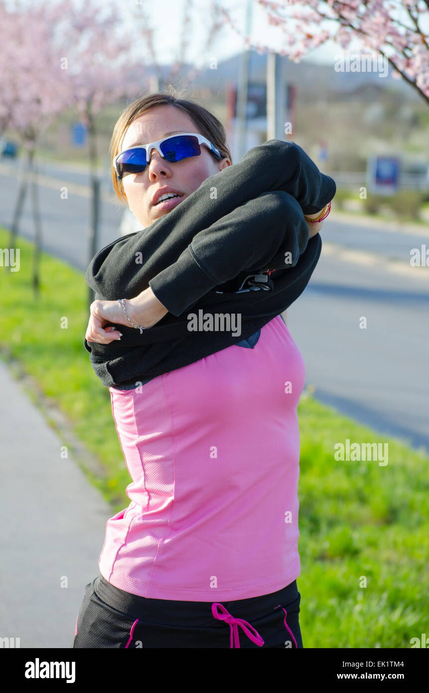 Young girl changing clothes for a workout outdoors Stock Photo