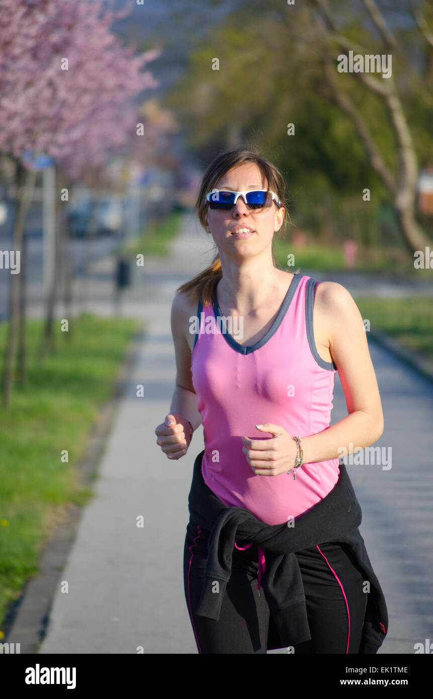 Young girl jogging on a sunny spring day Stock Photo