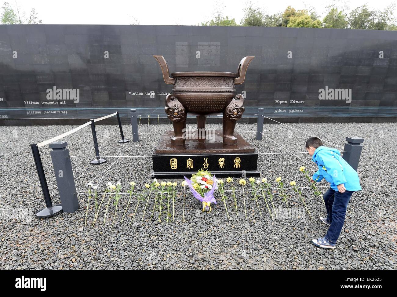 Nanjing, China's Jiangsu Province. 5th Apr, 2015. A resident lays a flower as she mourns the Nanjing Massacre victims at the Memorial Hall of the Victims in Nanjing Massacre by Japanese Invaders on the Qingming Festival in Nanjing, capital of east China's Jiangsu Province, April 5, 2015. Japanese troops captured Nanjing, then China's capital, on Dec. 13 of 1937 and started a 40-odd-day slaughter. More than 300,000 Chinese soldiers who had laid down their arms and civilians were murdered, and over 20,000 women were raped. © Sun Can/Xinhua/Alamy Live News Stock Photo