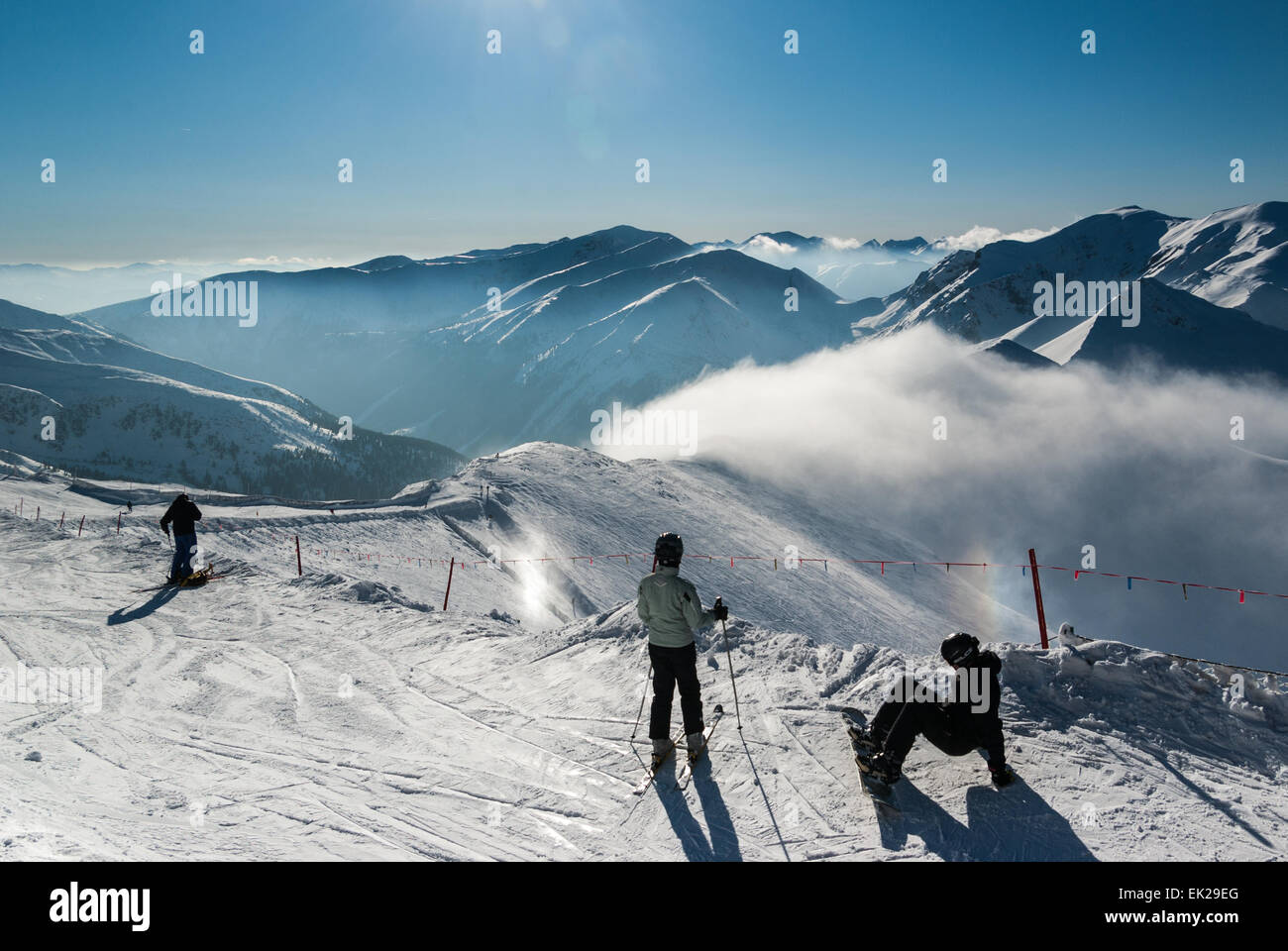 Skiers and Snowboarder and Western Tatras visible from Kasprowy Wierch, southern Poland Stock Photo