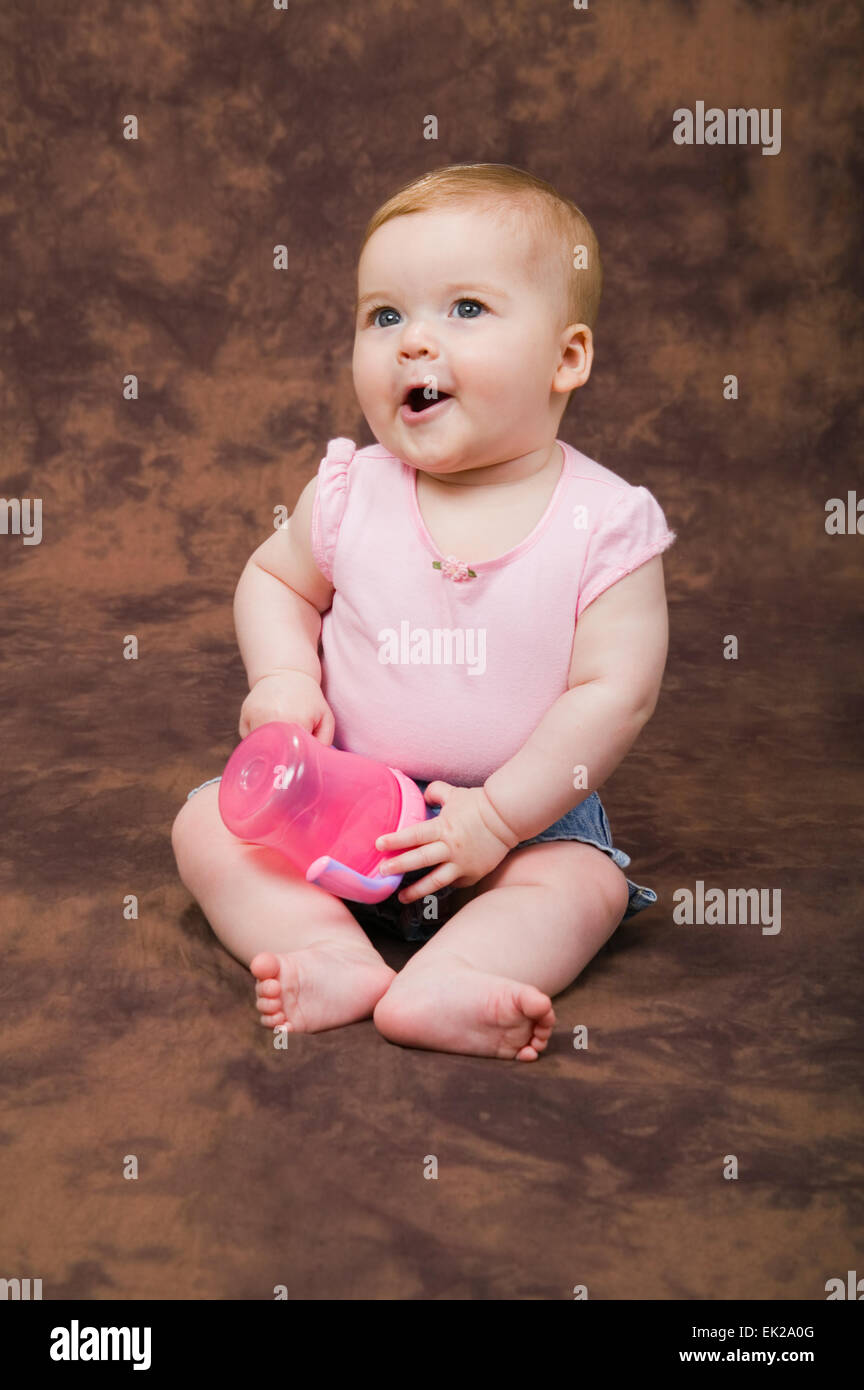 6 month old girl playing with her sippy cup Stock Photo Alamy