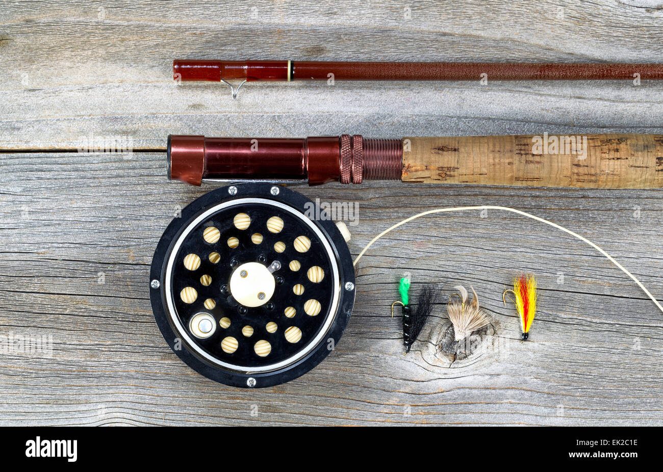 Antique fly fishing reel and rod on rustic wood. Layout in horizontal format. Stock Photo