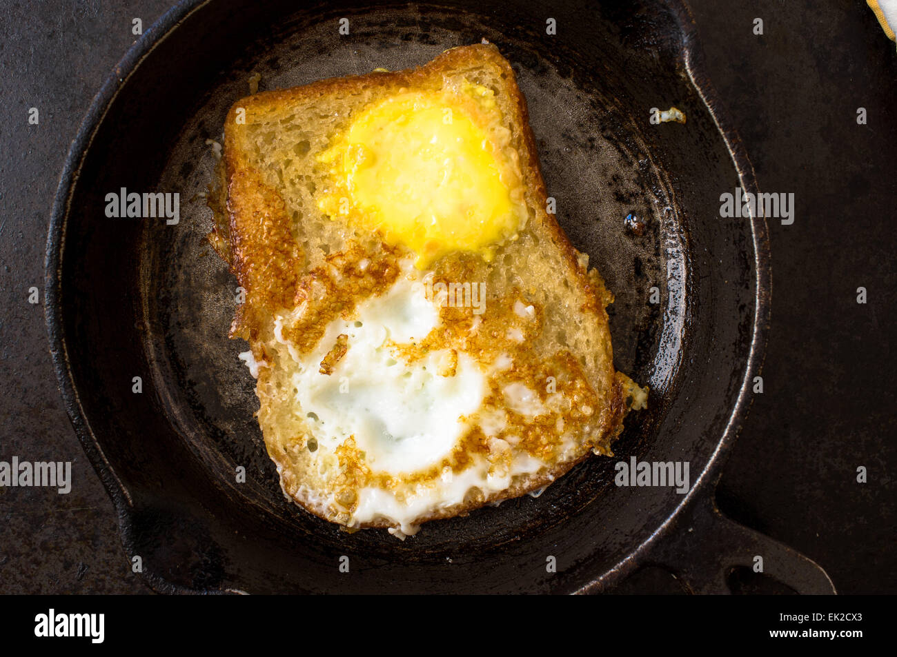 Frying pan with a sandwich with an egg on the stove while cooking Stock
