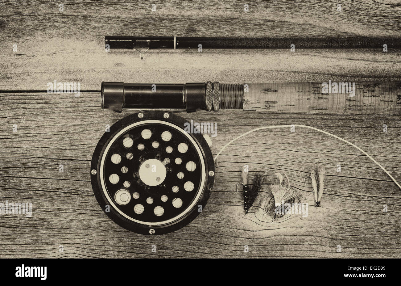 Vintage concept of an antique fly fishing reel and rod on rustic wood. Layout in horizontal format. Stock Photo