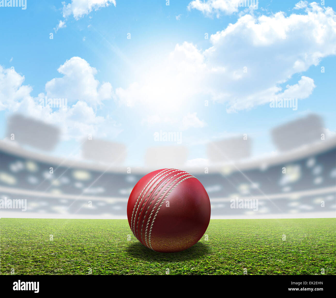 A cricket stadium with a red leather cricket ball on an unmarked green