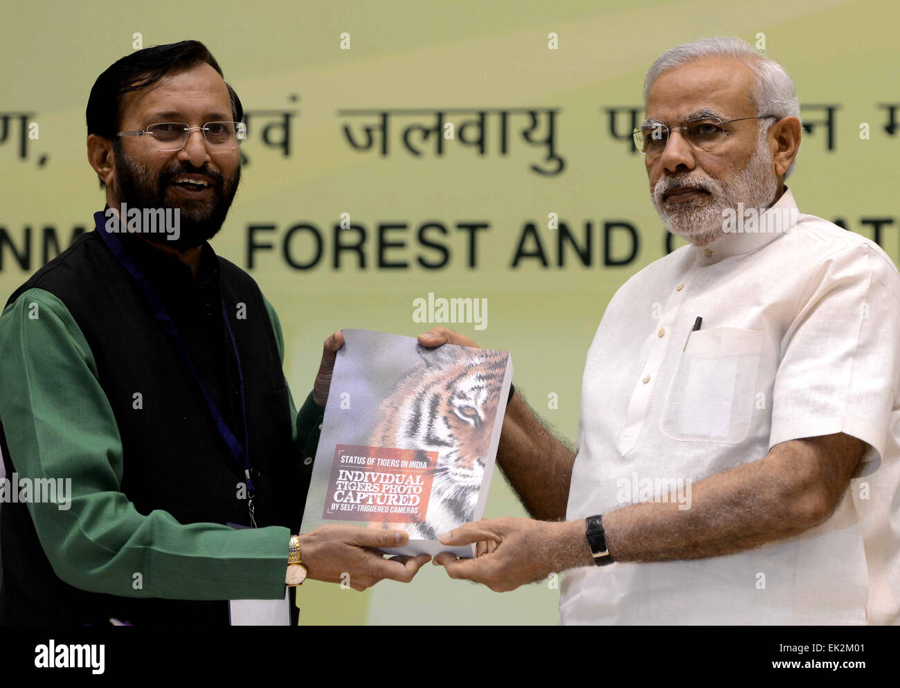 New Delhi, India. 6th Apr, 2015. Indian Environment Minister Prakash Javadekar (L) presents a copy of the latest tiger census report to Indian Prime Minister Narendra Modi during a conference organised by the Indian Environment Ministry in New Delhi, India, April 6, 2015. Indian Prime Minister Narendra Modi on Monday launched the National Air Quality Index so as to monitor pollution levels in 10 major cities. Credit:  Partha Sarkar/Xinhua/Alamy Live News Stock Photo