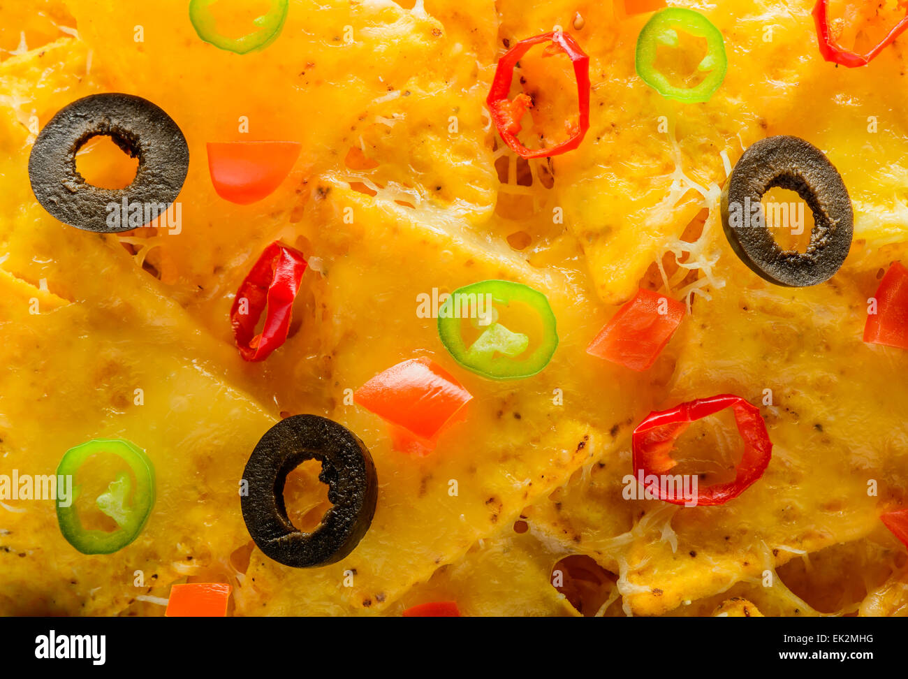 closeup detail of nacho tortilla chips with olives and chili peppers Stock Photo