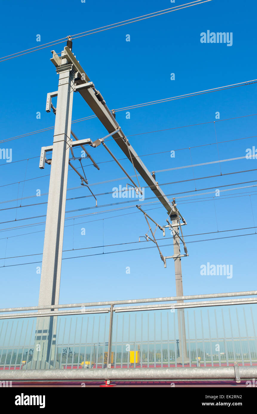 railway catenary against a blue sky Stock Photo