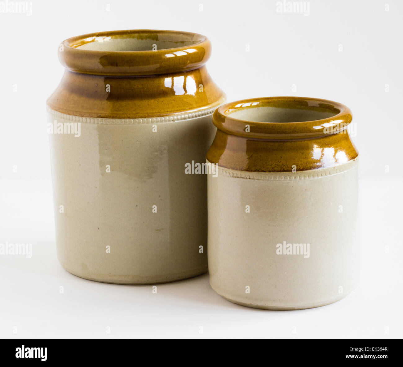 Two rustic glazed earthenware jars isolated on white background Stock
