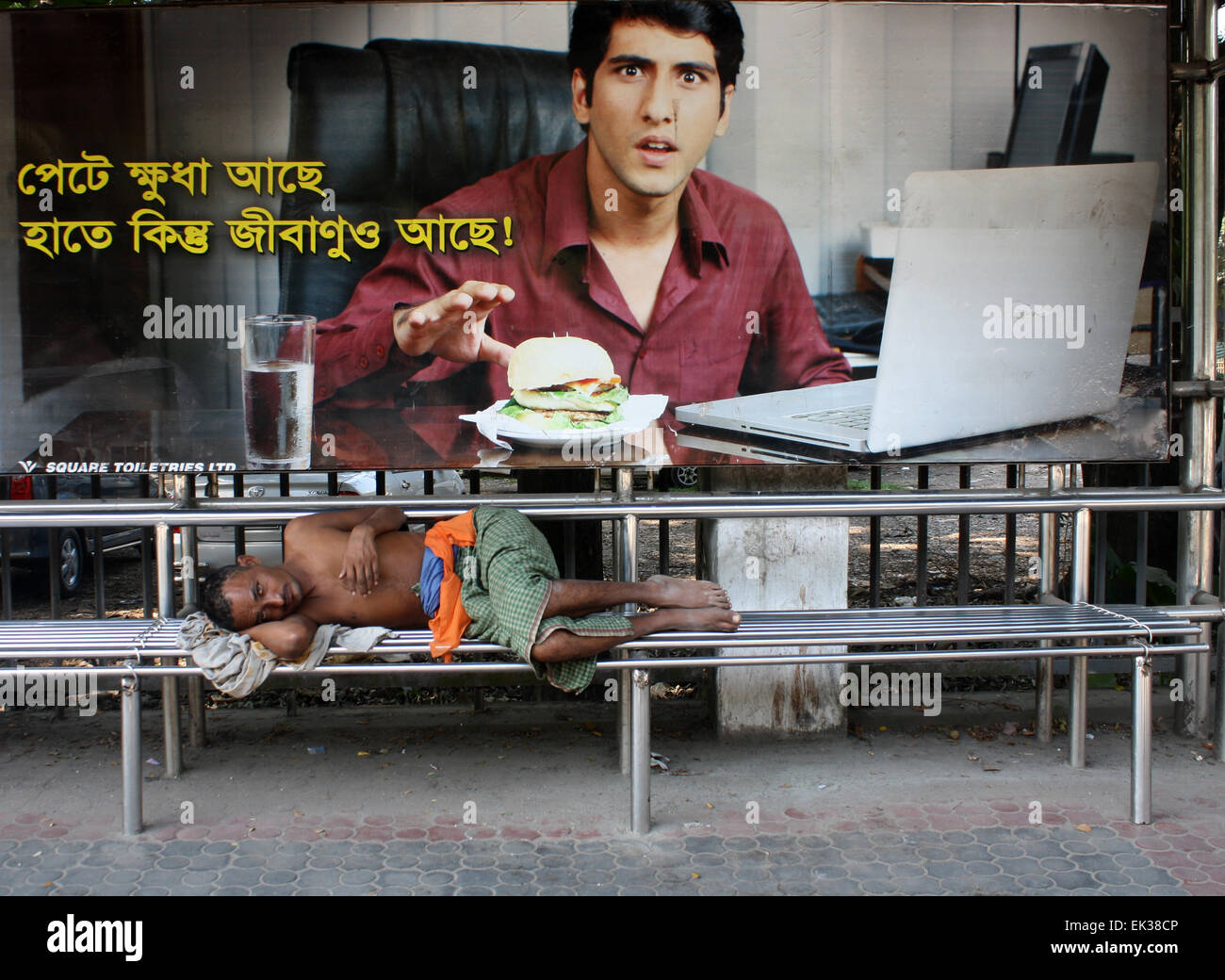 A Bangladeshi homeless people taking a nap on the Bus Stop at Dhaka University are in Dhaka, Bangladesh. Stock Photo