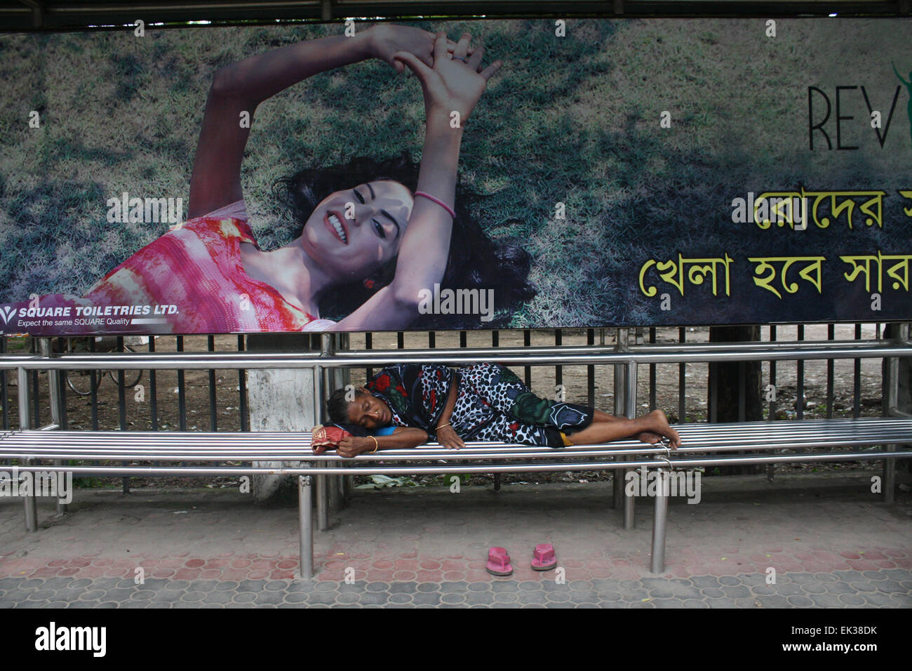 A homeless woman taking a nap on the Bus stop at Dhaka University area in Dhaka, Bangladesh. Stock Photo