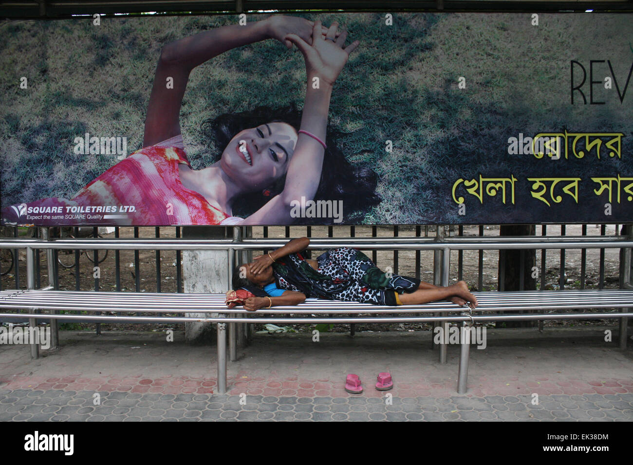 A homeless woman taking a nap on the Bus stop at Dhaka University area in Dhaka, Bangladesh. Stock Photo