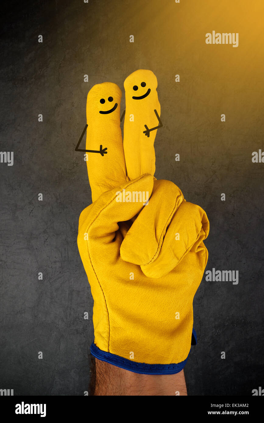 Two Happy Laughing Smileys on Fingers of Yellow Leather Protective Construction Industry Working Gloves Stock Photo