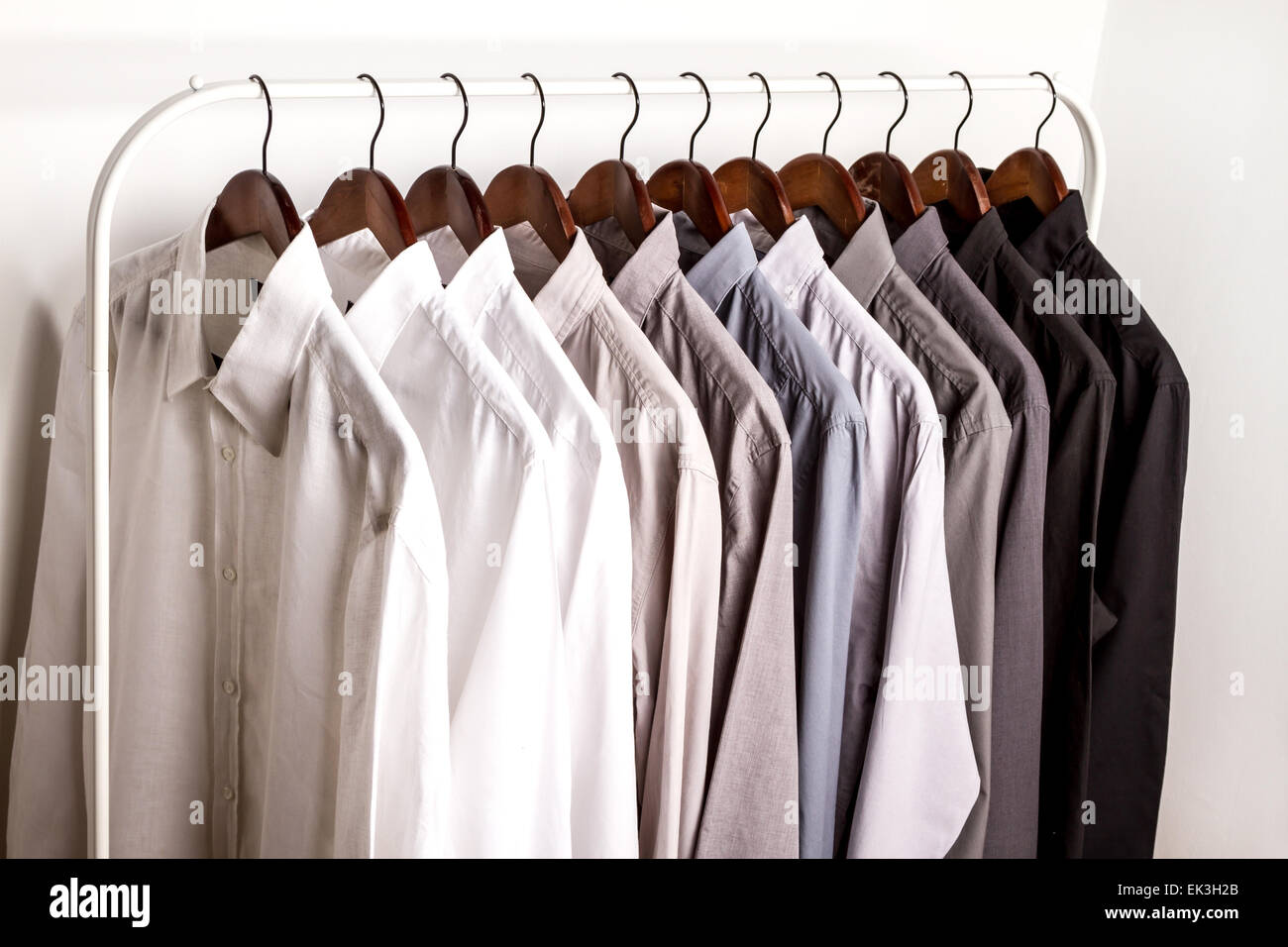 Several shirts on a hanger from white to black color range Stock Photo