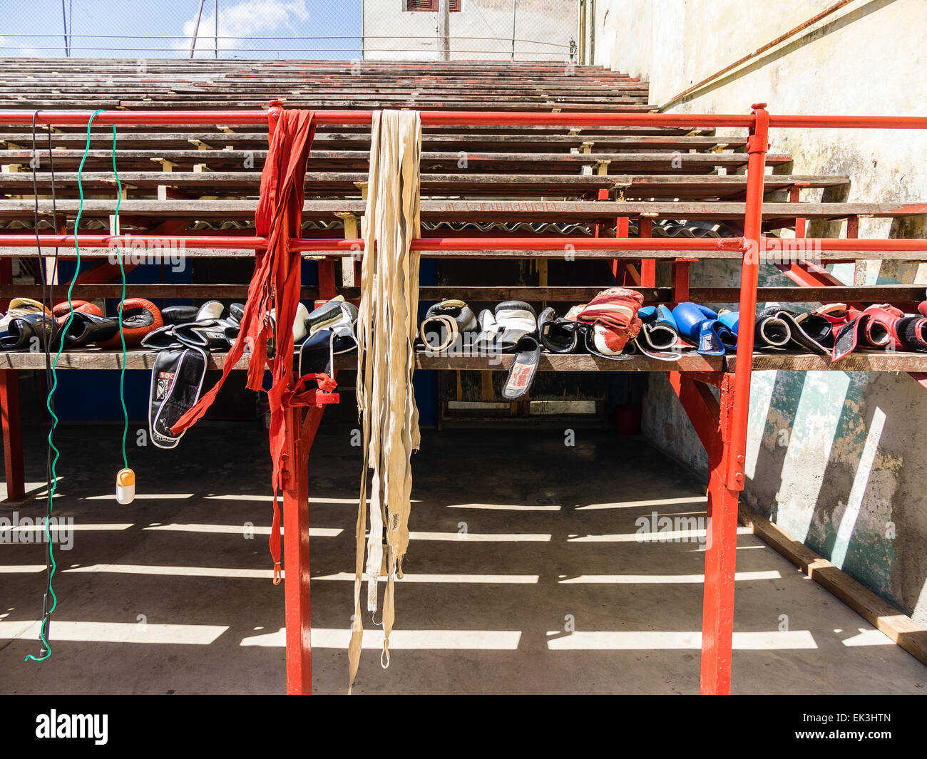 A row of various colored boxing gloves lined up on wooden stadium bench at the Rafael Trejo Boxing Gym in Havana, Cuba. Stock Photo