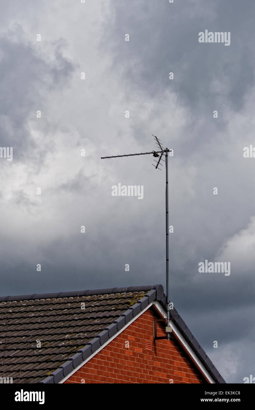 Basic television aerial/antenna on the roof of a house against a grey