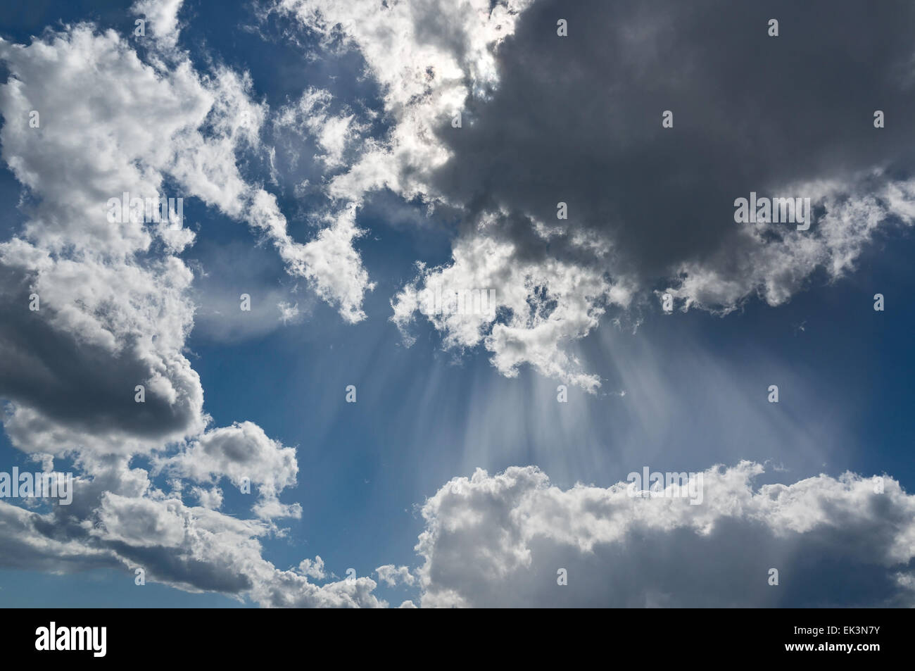 Sunbeams among clouds in the sky Stock Photo