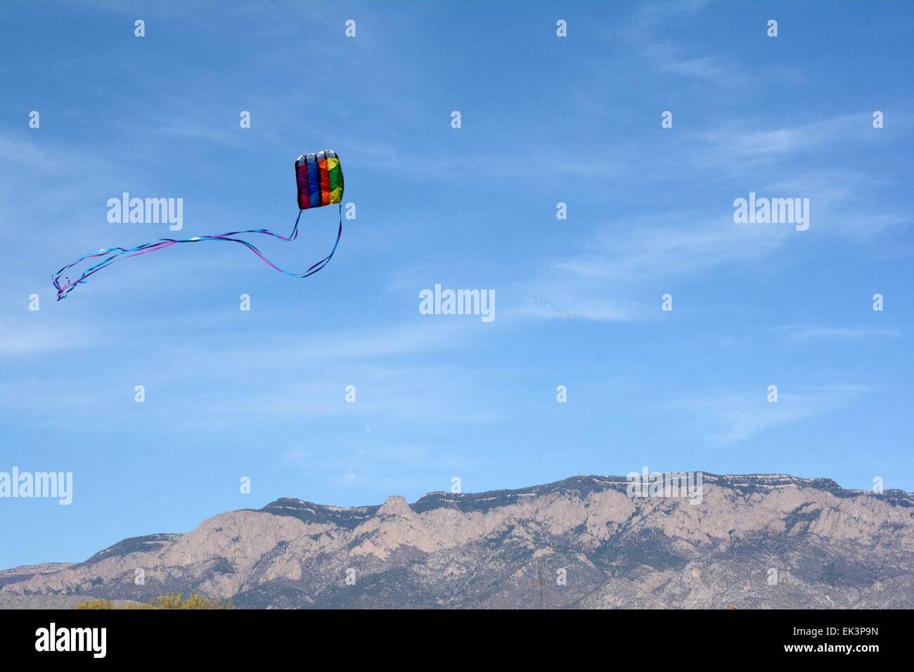 Kite with tails soaring in the wind, mountains in distance Albuquerque, New Mexico - USA Stock Photo