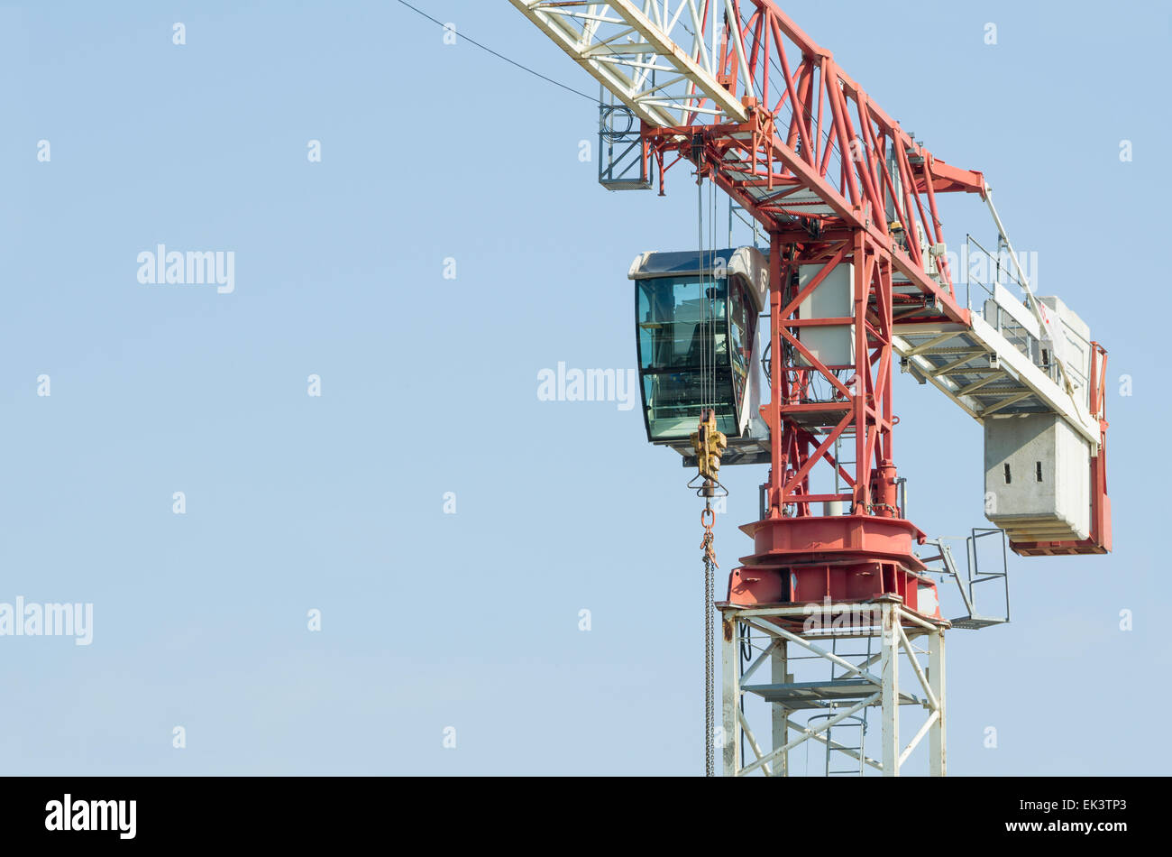 White and Red Tower Crane Closeup with Solid Blue Sky Stock Photo