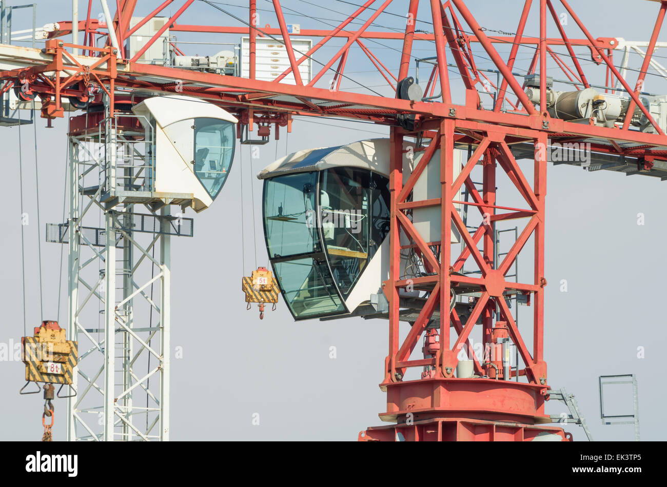 White and Red Tower Crane Operator Cabins Facing in front of Blue Sky Stock Photo