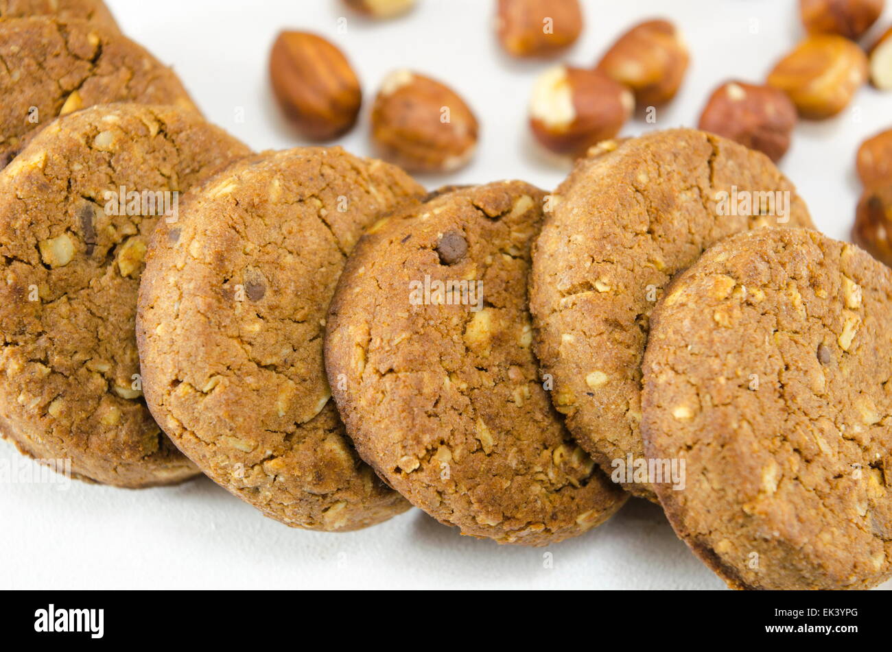 Integral biscuits on white background surrounded with hazelnuts Stock Photo