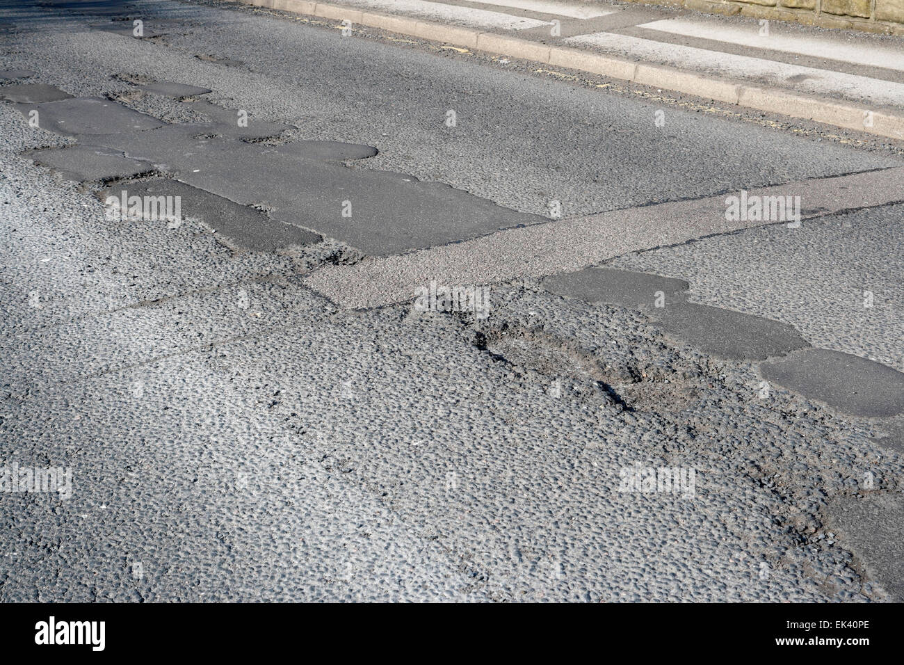 Uneven poor quality road surface patched repairs, Archer road in Sheffield England Stock Photo