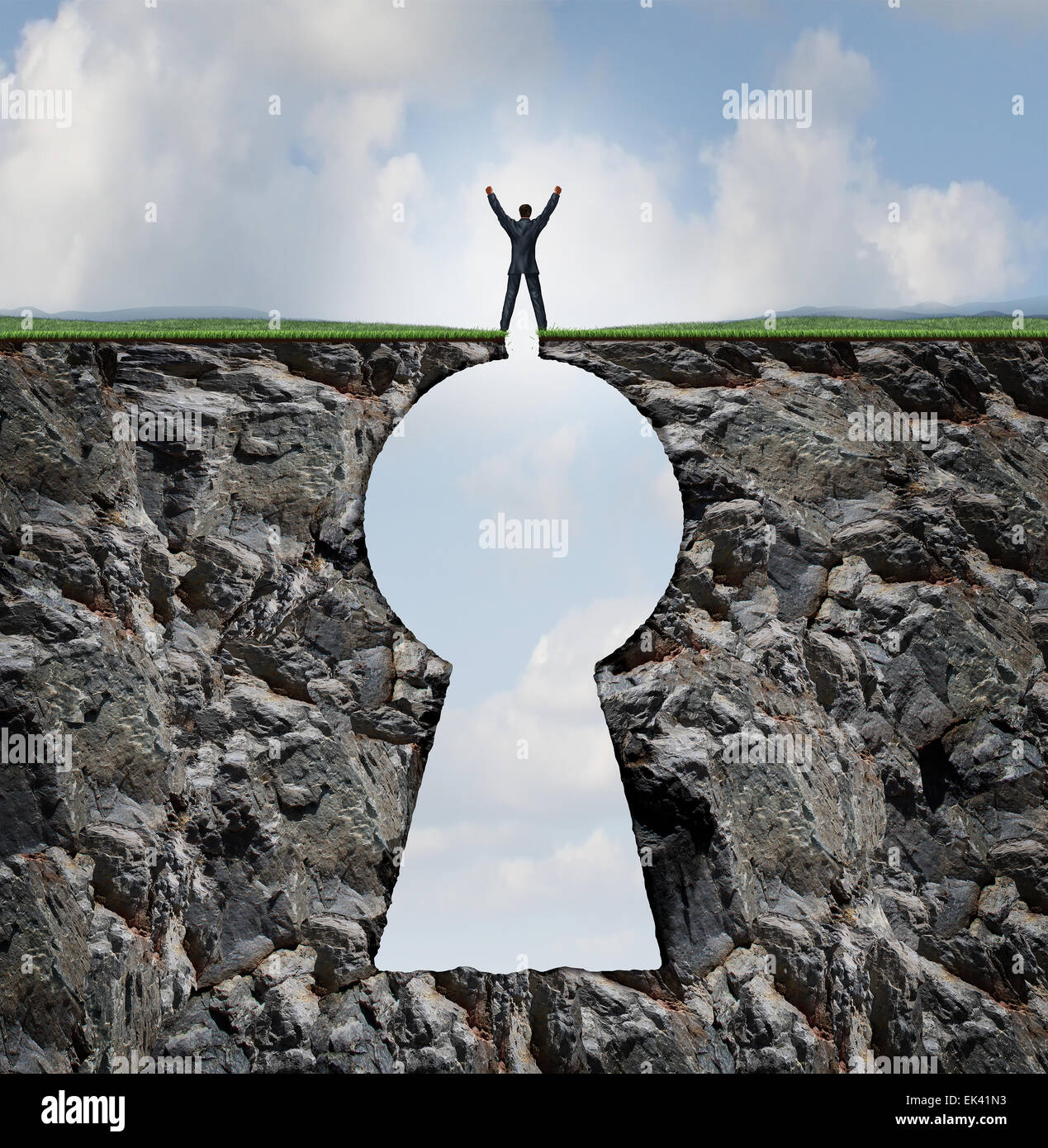 Businessman standing on keyhole mountain cliff as a person with arms up in victory on top of a rock mountain shaped as a key hole business and finance symbol for financial and life success. Stock Photo